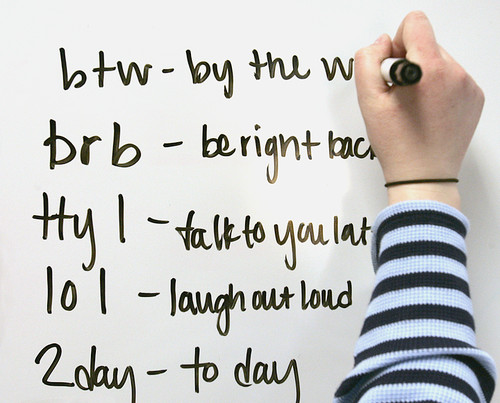 whiteboard with commonly used texting abbreviation examples